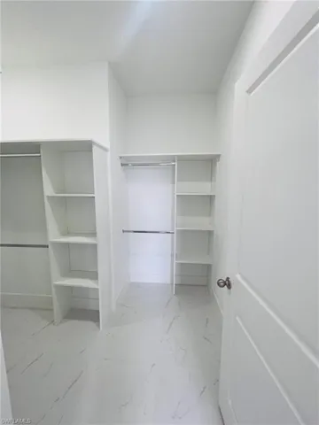 Walk in closet with marble finish floor