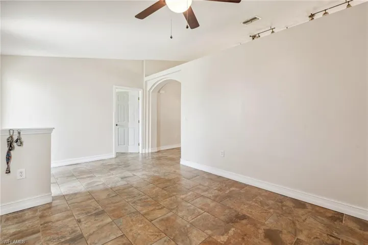 Spare room featuring ceiling fan, rail lighting, tile patterned flooring, and lofted ceiling