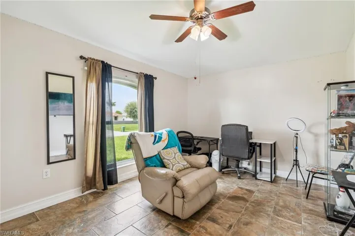 Living area with tile patterned floors and ceiling fan