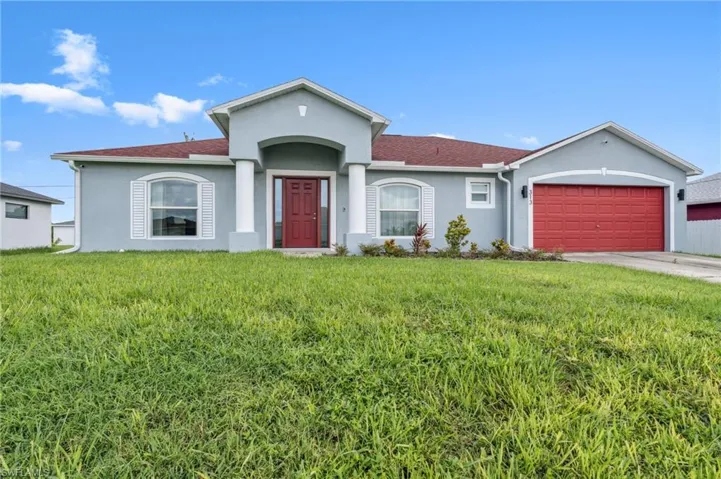 Ranch-style home with a front lawn and a garage