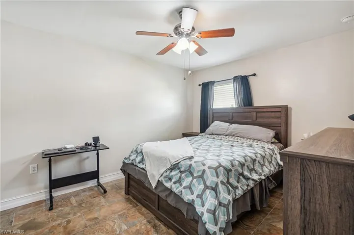 Bedroom with tile patterned floors and ceiling fan