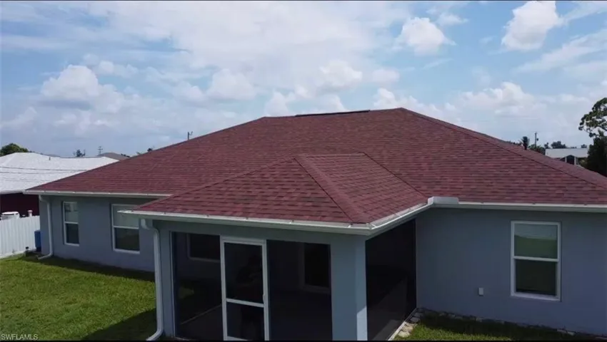Back of house with a sunroom and a yard