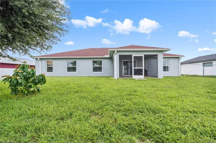 Rear view of house with a sunroom and a yard
