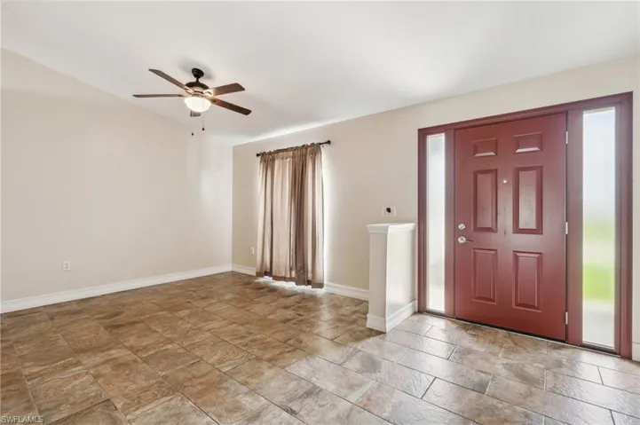 Foyer with tile patterned floors, ceiling fan, and a wealth of natural light