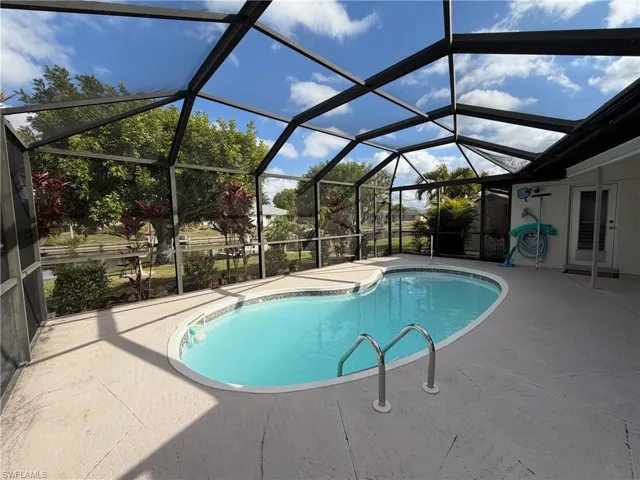 screened in pool area over looking canal with a pool bath entrance