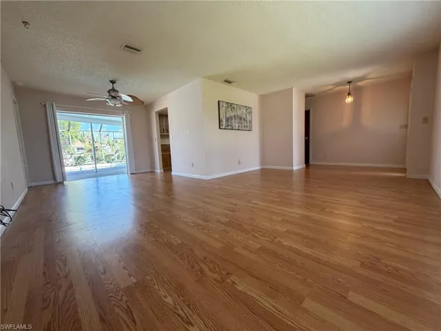 Living room and dining area with pocket sliders leading out to lanai and screened in pool area overlooking cana