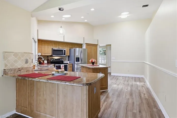 Kitchen featuring wood cabinetry, stainless steel appliances, and granite countertops