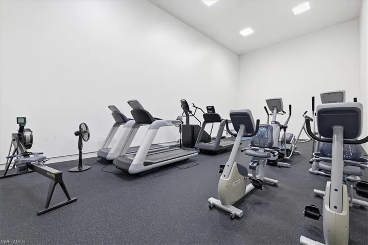 Dedicated fitness room featuring recessed lighting, a durable rubberized floor, and white walls