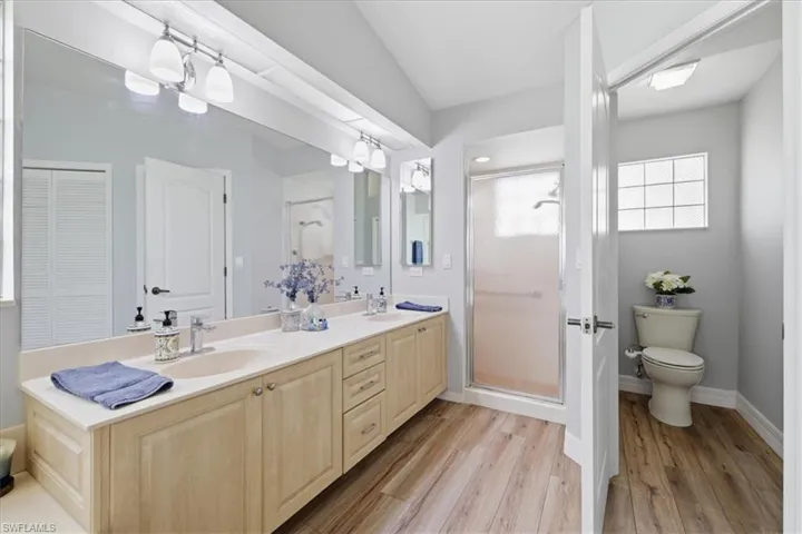 Double vanity with light wood-finish cabinetry and light-colored countertops