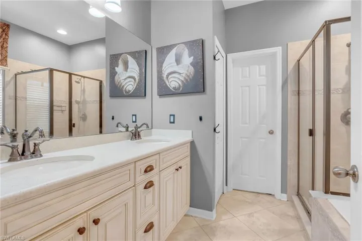 Bathroom with tile patterned floors, separate shower and tub, and vanity