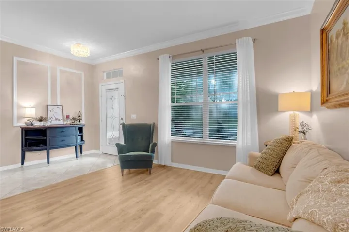 Living room featuring ornamental molding and light tile patterned floors