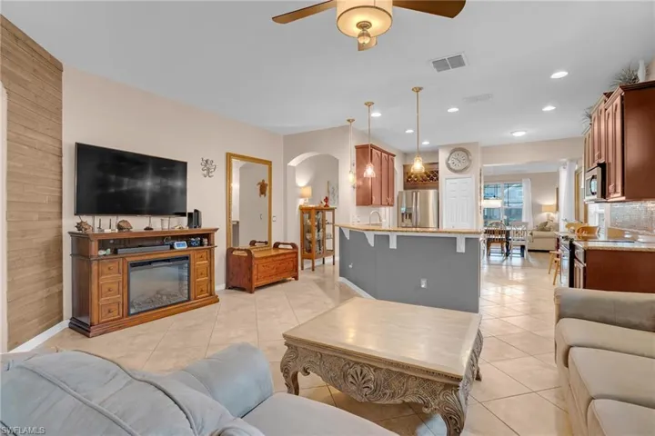 Tiled living room featuring ceiling fan and wooden walls