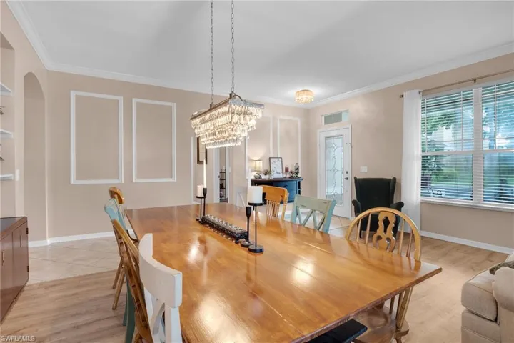 Dining space featuring light wood-type flooring, a chandelier, and crown molding