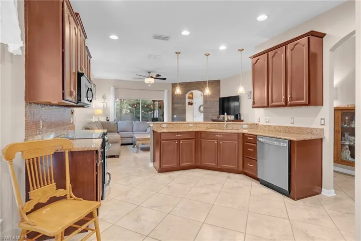 Kitchen with ceiling fan, sink, appliances with stainless steel finishes, and kitchen peninsula