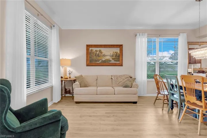 Living room featuring crown molding, a chandelier, and light hardwood / wood-style floors