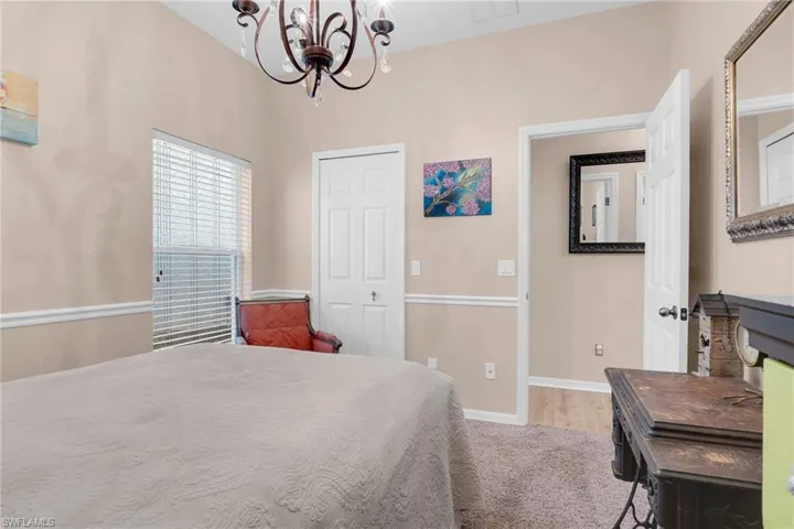 Bedroom with a closet, hardwood / wood-style flooring, and a notable chandelier