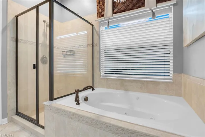 Bathroom featuring shower with separate bathtub and tile patterned floors
