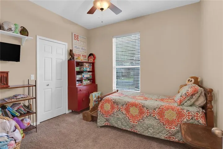 Bedroom with a closet, ceiling fan, and carpet