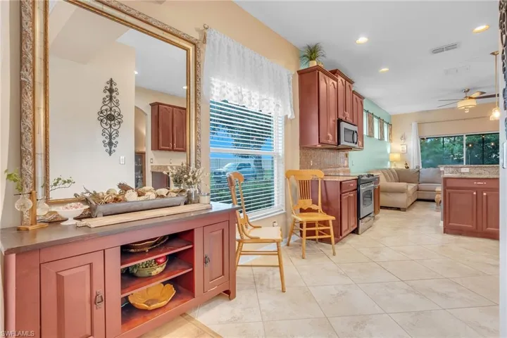 Kitchen with a healthy amount of sunlight, appliances with stainless steel finishes, decorative backsplash, and ceiling fan