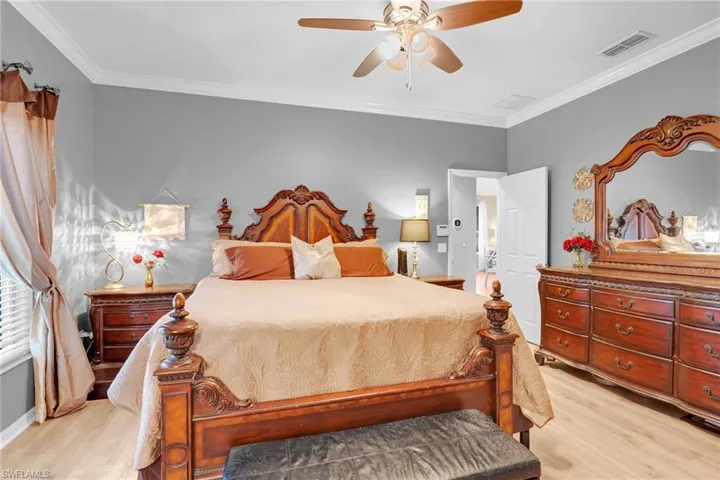 Bedroom featuring crown molding, light hardwood / wood-style flooring, and ceiling fan