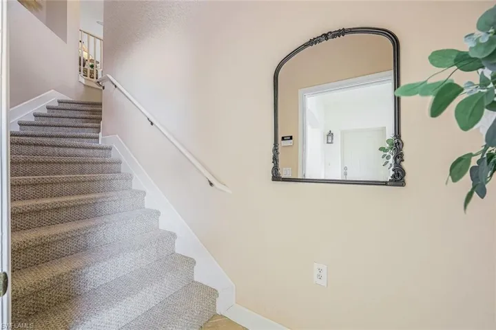 Interior entry at ground level with wide stairway and decorative niche