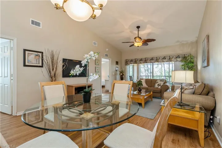 Dining area with vaulted ceiling, light hardwood / wood-style flooring, and ceiling fan