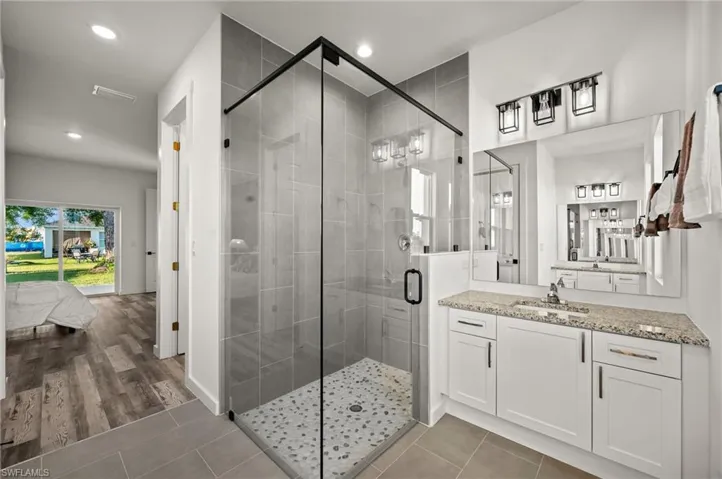 Bathroom with walk in shower, vanity, and tile floors