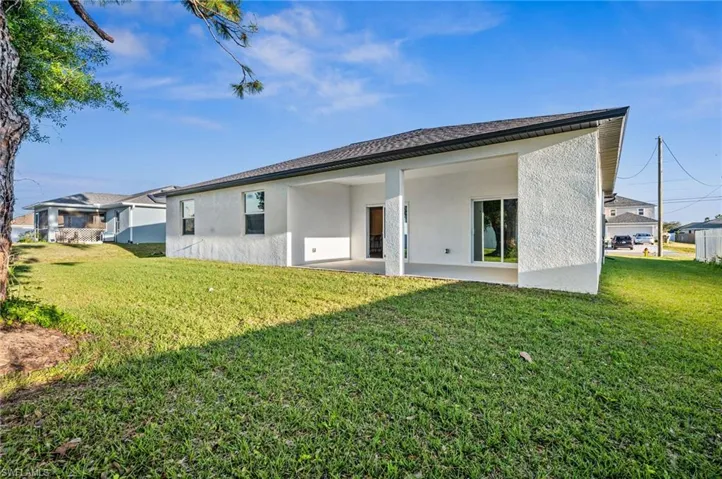 Back of property with a lawn
