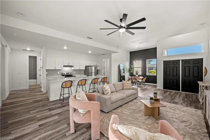 Living room with ceiling fan and hardwood / wood-style flooring