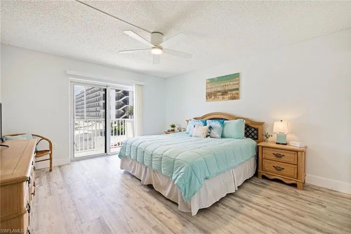 Bedroom featuring a textured ceiling, light wood-style flooring, a ceiling fan, and access to outside
