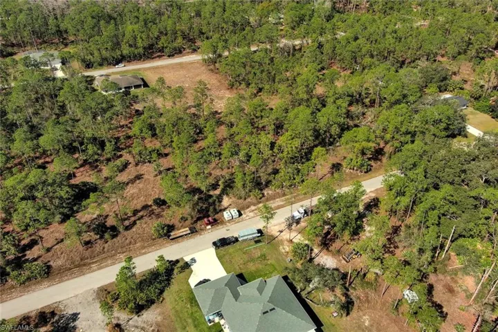 Aerial overview of property's location with a heavily wooded area