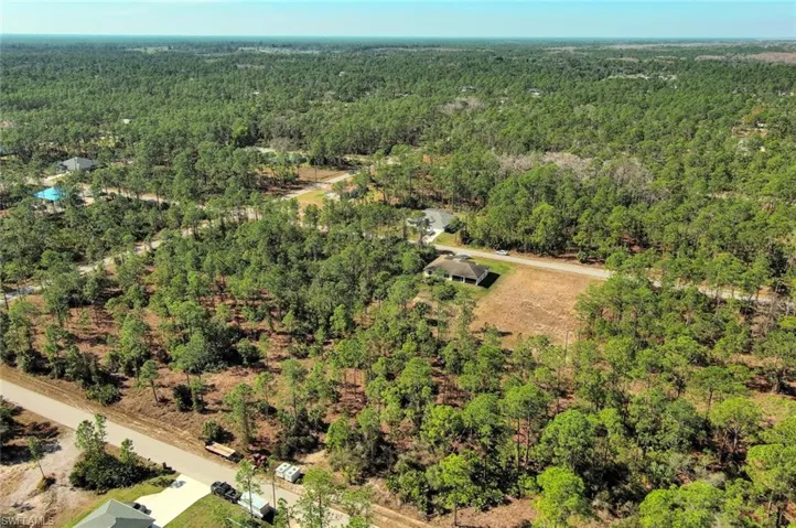 Aerial view of property's location featuring a heavily wooded area