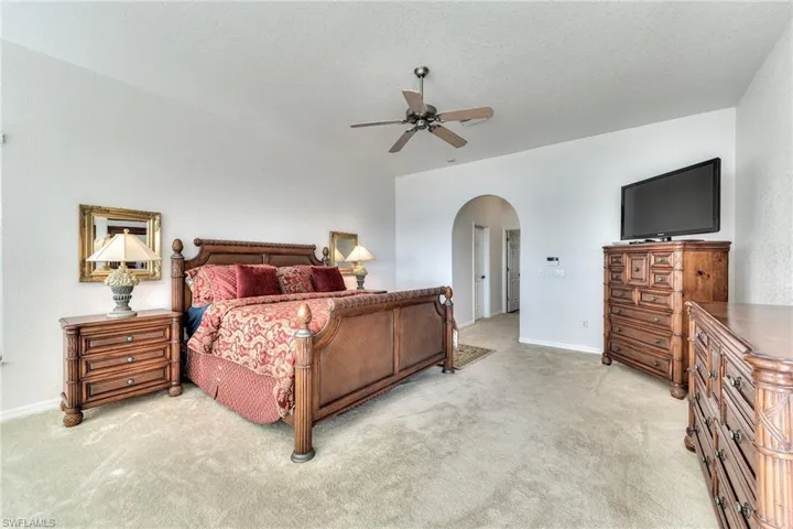 Carpeted bedroom featuring ceiling fan and a textured ceiling