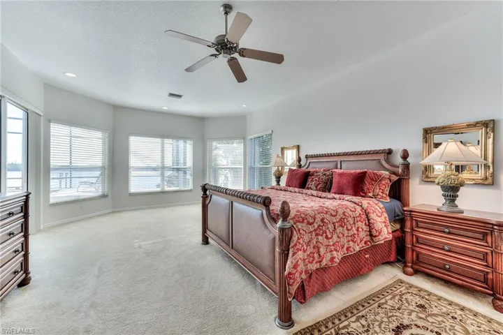 Carpeted bedroom featuring ceiling fan