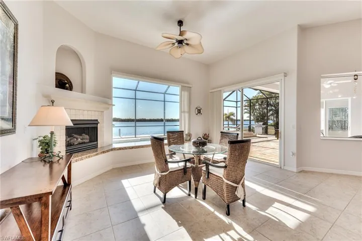 Tiled dining room featuring ceiling fan, a water view, a tile fireplace, and a wealth of natural light