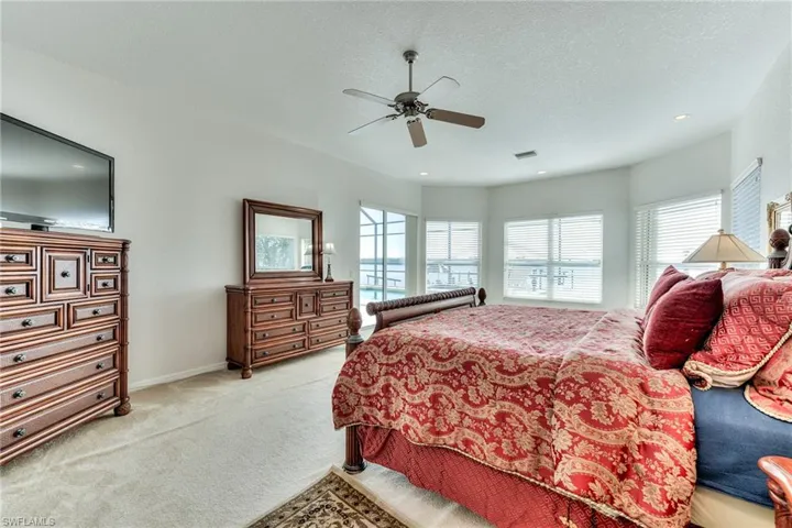 Carpeted bedroom featuring a textured ceiling and ceiling fan