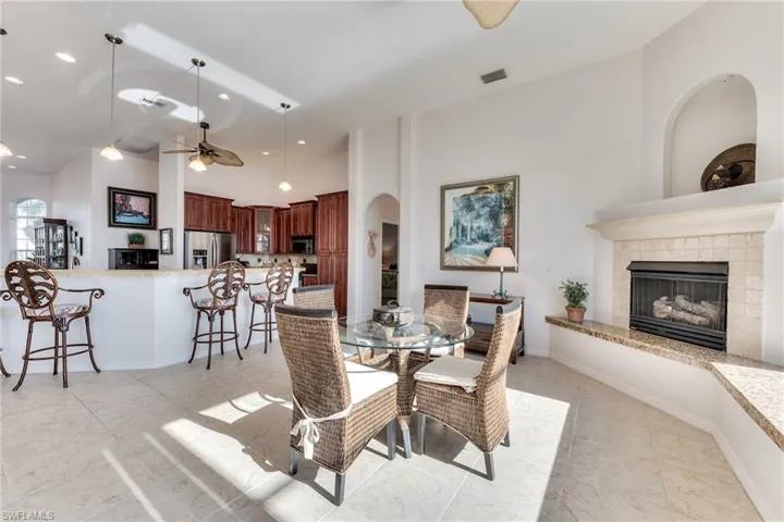 Dining space featuring ceiling fan and a fireplace