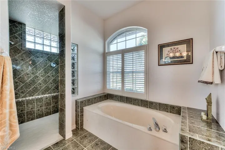 Bathroom featuring tile patterned floors and shower with separate bathtub