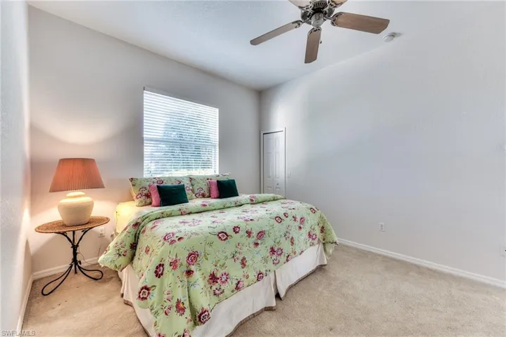 Bedroom with light carpet, a closet, and ceiling fan