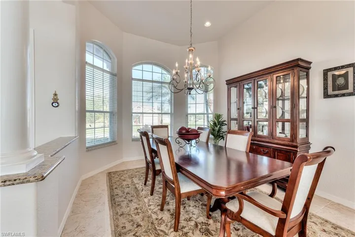 Dining space featuring ornate columns and a notable chandelier