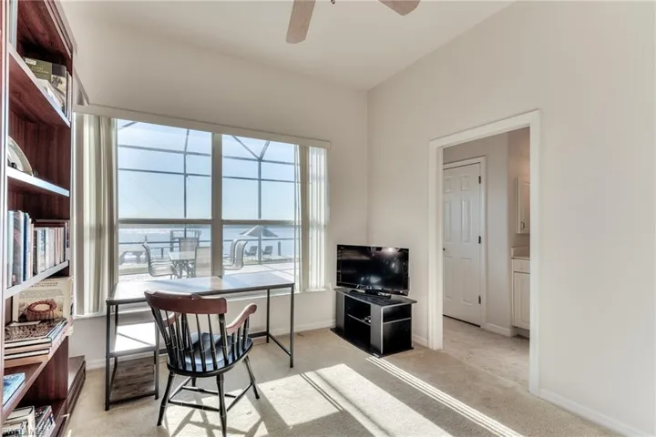 Office area with light carpet and ceiling fan