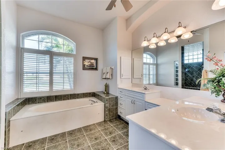 Bathroom with a bathtub, a wealth of natural light, and vanity