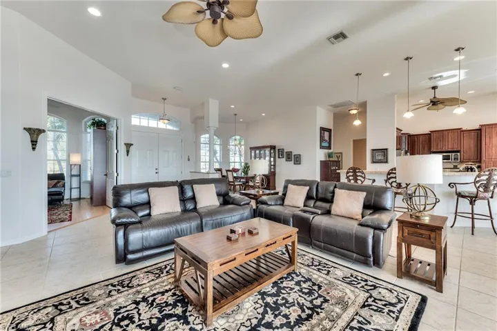Tiled living room featuring ceiling fan and a high ceiling