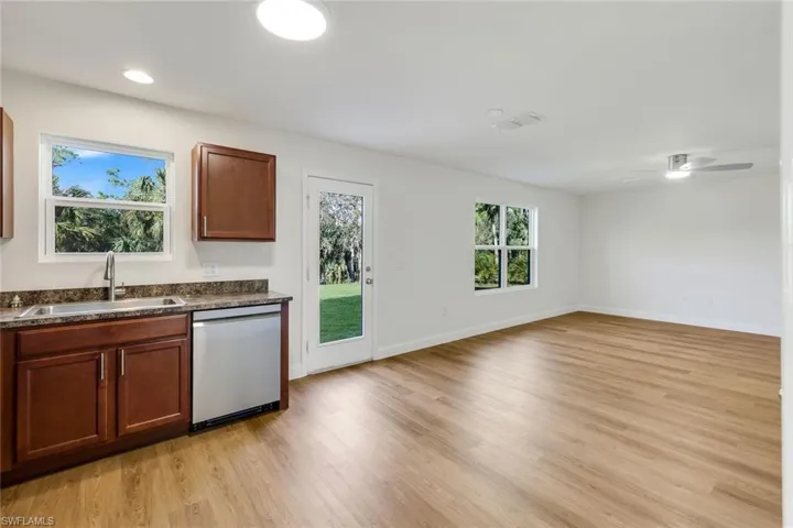 Kitchen featuring dishwasher, light hardwood / wood-style floors, sink, and ceiling fan