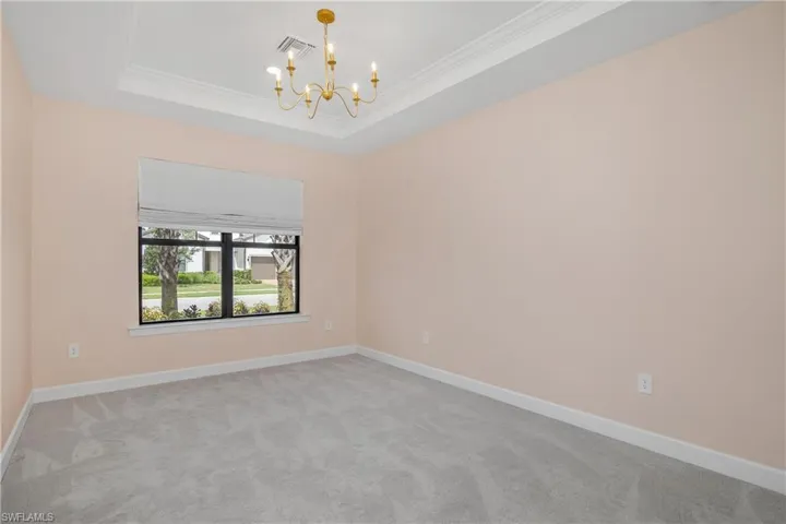 Spacious ensuite 2 with molding, a chandelier, and a tray ceiling