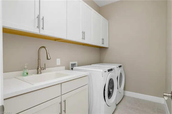 1st floor laundry with cabinets and sink