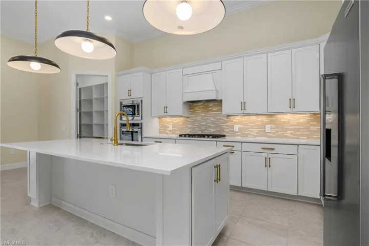 Kitchen with a center island with sink, stainless steel appliances, and white cabinets