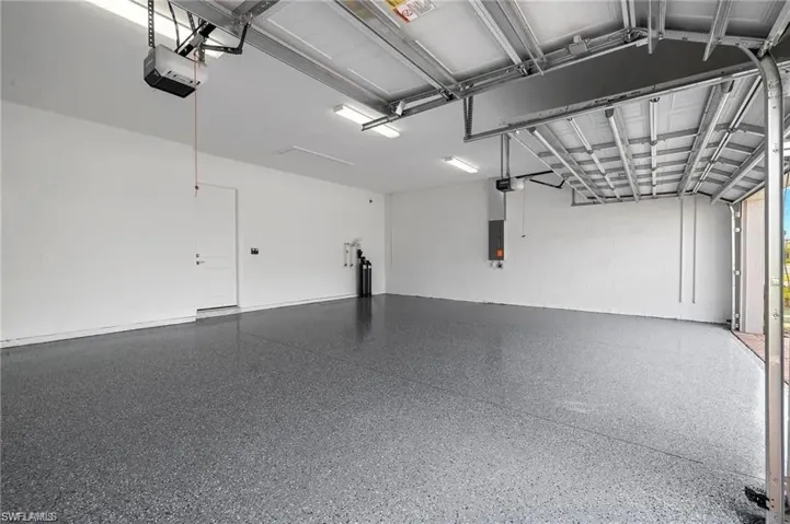Garage featuring a garage door opener and electric panel