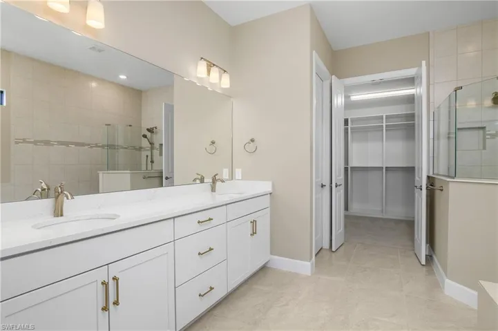Bathroom with tiled shower, vanity, and tile patterned flooring and separate soaking tub