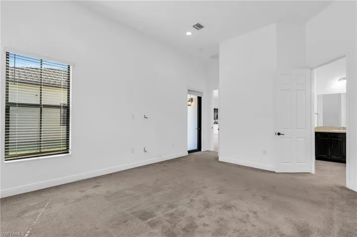 Carpeted spare room with a towering ceiling